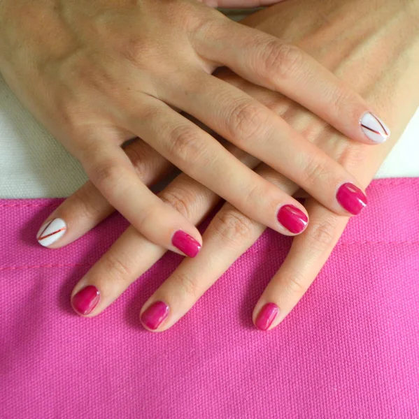 Manicura uñas rojas cortas y blancas en el dedo índice —  Fotos de Stock