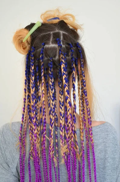 色とりどりのおしゃれなセットを持つ少女は カネカロンをお下げ 髪の色の人工繊維 編むための材料 — ストック写真