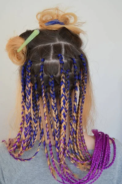 一个女孩与一套时髦的多彩的辫子 Kanekalon 彩色人工股的头发 编结材料 — 图库照片