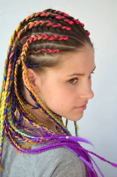 一个女孩与一套时髦的多彩的辫子 Kanekalon 彩色人工股的头发 编结材料 — 图库照片