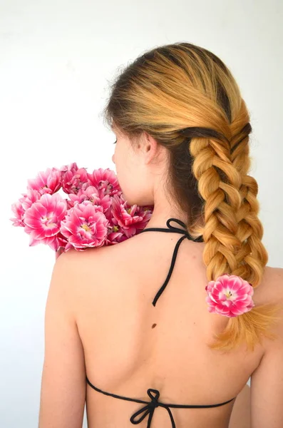 チューリップの花束を持つ美しいヘアドレスを持つ少女は コロンバスの一種です つの繊維で編んだ髪 — ストック写真