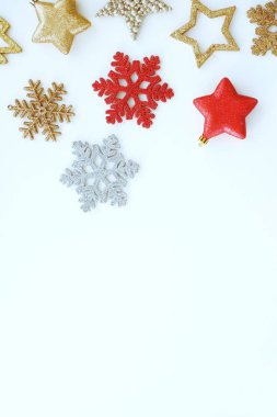 Noel ve Yeni Yıl kompozisyonu. Beyaz arka planda altın, gümüş ve kırmızı Noel süsleri. Üst görünüm, metin için boşluk kopyala.