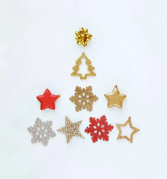 Beyaz arka planda noel süslemelerinden yapılmış yaratıcı bir Noel ağacı. Minimalist tatil konsepti. Kare, üst görünüm, metin için boşluk kopyala.