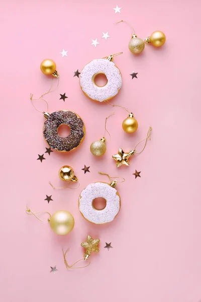 Kar tanelerinin, yıldızların, konfetilerin, baloların, pembe arka planda altın ve beyaz çöreklerin Noel kompozisyon dekorasyonunun en üst görüntüsü. Noel ve Yeni Yıl 'ın kutlu olsun. Dikey, Düz Yatay.
