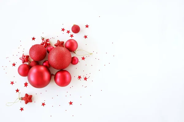 Kırmızı topların beyaz arka plandaki dekorasyonundan kalma düz bir Noel arkaplanı vardı. Yaratıcı minimalist tatil konsepti. Kopyalama alanı olan üst görünüm.