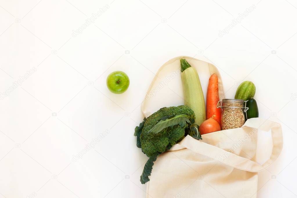 Reusable textile cotton bag with a set of products, vegetables for a healthy balanced diet. Zero waste concept, storage and recycling, eco friendly lifestyle. Top view with copy space for text.