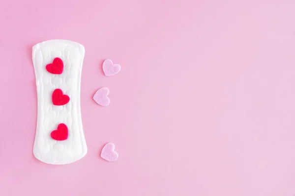 Sanitary pad on a pink background. An alternative choice of feminine hygiene products. Menstrual mothly cycle, means of protection. Top view, flat lay, copy space for text.