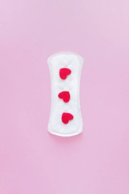 Pembe arka planda hijyenik ped. Alternatif kadın hijyen ürünleri seçimi. Aybaşı pervane döngüsü, korunma aracı. Dikey, Üst Görünüm, düz yatış.