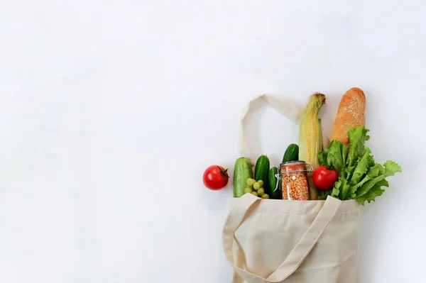 Various fresh vegetables and fruits, bread, cereals beans in an eco reusable bag. Zero waste concept, Healthy clean food. Top view, copy space for text.