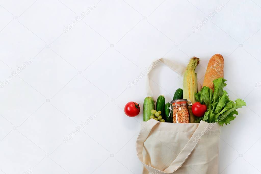 Various fresh vegetables and fruits, bread, cereals beans in an eco reusable bag. Zero waste concept, Healthy clean food. Top view, copy space for text.