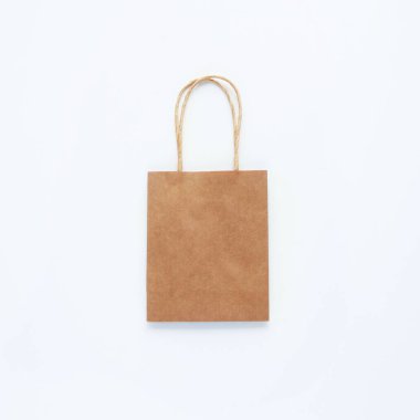 Beyaz arka planda kahverengi bir alışveriş çantası. Sıfır atık kavramı, makul tüketim, geri dönüşüm, indirim. Kare, üst manzara, düz yatış. Metin için alanı kopyala.