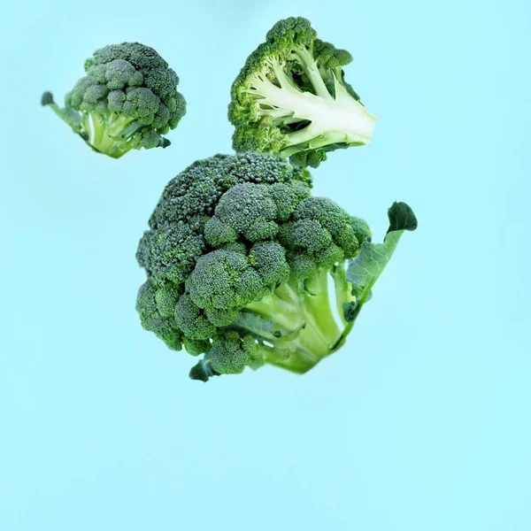 Flyvende Grønne Broccoli Skiver Blå Baggrund Begrebet Flyvende Mad Grønne - Stock-foto