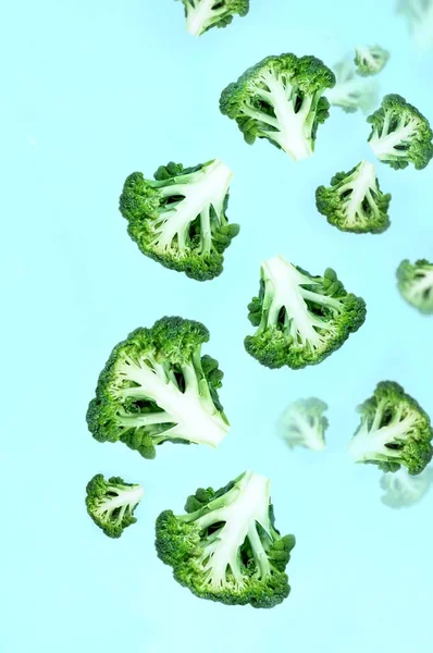 Fallande Svävande Gröna Broccoli Skivor Blå Bakgrund Begreppet Flygande Mat — Stockfoto