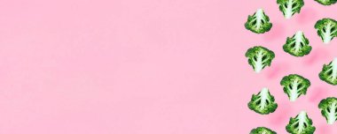 Pembe arka planda brokoli olan kusursuz minimalist desen. Fotoğraf kolajı, vegan pop sanat tasarımı, diyet, sağlıklı yiyecekler. Kenar kenarlı sebze bayrağı, Üst Manzara.