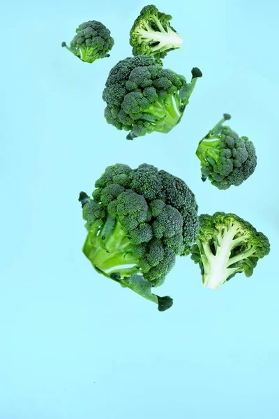 Flyvende Grønne Broccoli Skiver Blå Baggrund Koncept Flyvende Mad Grønne - Stock-foto