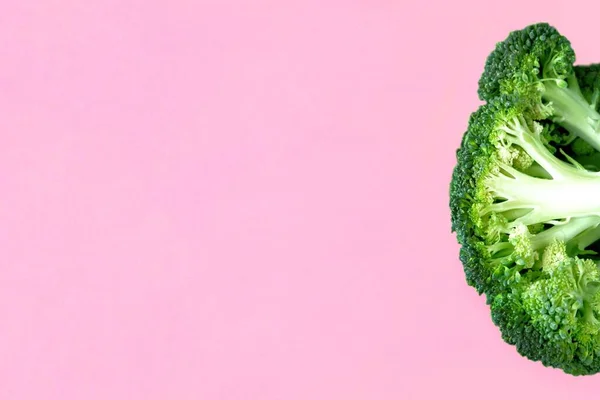 ピンクの背景に新鮮な生ブロッコリーの半分 要旨野菜の背景 バナー キャベツの食感の詳細 テキストのコピースペースとのクローズアップ トップビュー フラットレイアウト — ストック写真