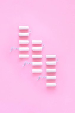 Pembe arka planda beyaz hijyenik tampon deseni. Adet döngüsü, koruyucu ekipmanlar, kadın hijyeni. Dikey, Üst Görünüm, Düz Yatay, Kopyala.