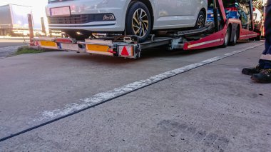 Otoyoldaki bir dinlenme yerinde yeni araçlarla dolu bir kamyon nakliyecisi.