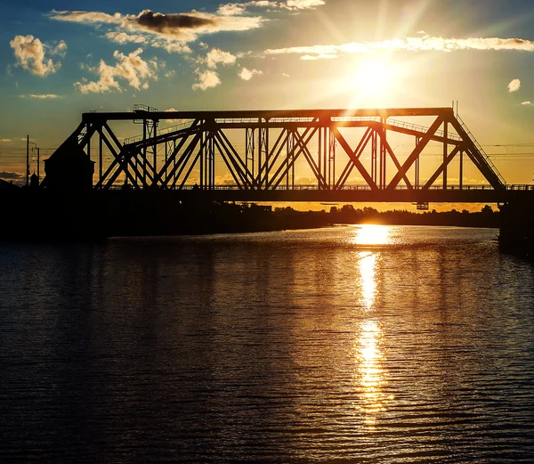 Vasúti híd a folyón, a naplemente — Stock Fotó