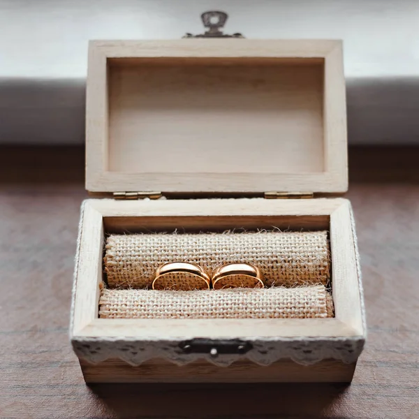 Gouden ringen in houten kist — Stockfoto