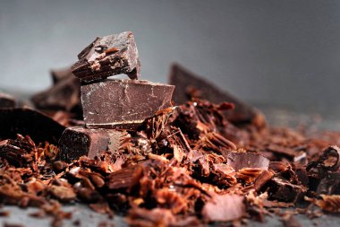 Koyu çikolata, kakao tozu ve kahve çekirdekleri ahşap bir masa üzerinde kırık