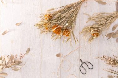 Tahta masadaki kuru çiçekler, mevsim arkaplanı.