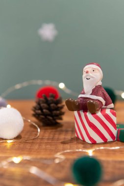 Yeşil zemin üzerinde Noel süslemesi (kardan adam, Noel baba, hediye kutusu, kozalak, çorap, ışık)