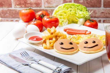 Gözleme, patates kızartması, Alman sosisi, yumurta, sebze ve içeceklerle kahvaltı masada.