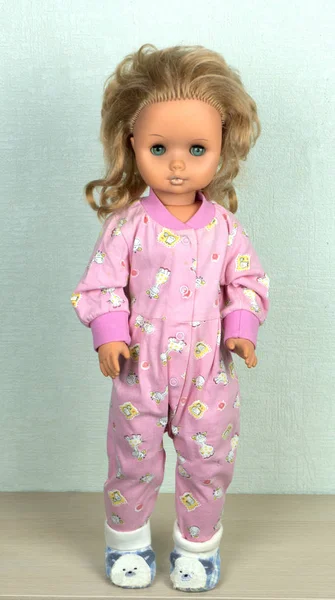 Beautiful old vintage baby doll in pink overalls, with golden hair — Stock Photo, Image