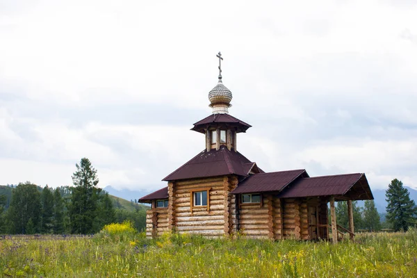 Kleiner orthodoxer Holztempel. aus dicken Baumstämmen. braunes Dach, Kreuz auf der Kuppel — Stockfoto