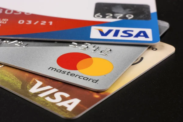 Tři bankovní kreditní karty s logy Visa a Mastercard na černém pozadí — Stock fotografie