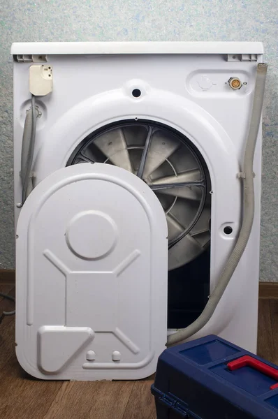 Repair of washing machines, repair of large household appliances. The back of the washing machine is removed, there is a tool box