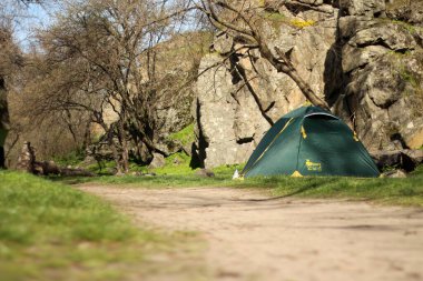 Kayaların arkasında turist çadırı
