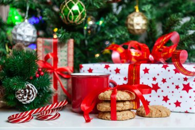 Noel hediyesi kutuları ve süslü Noel ağacının yanında tatlılar