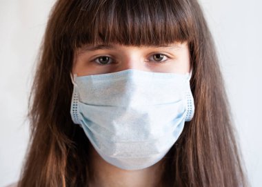 Tecritteki kız. Coronavirus 'a karşı yüzünde koruyucu tıbbi maske var. COVID-19 'u durdur