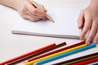 Çocukların elleri pastel boyalarla çizer. Üst görünüm