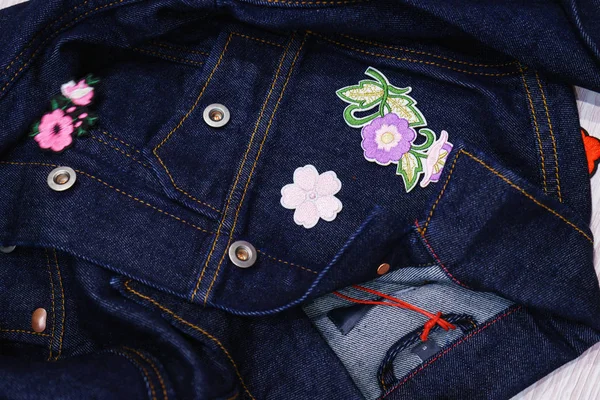 Process of decorating embroidery and stickers of a new denim jacket.