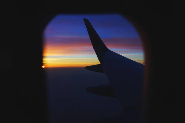 Traveling by plane. View from the window to the clouds and dawn.