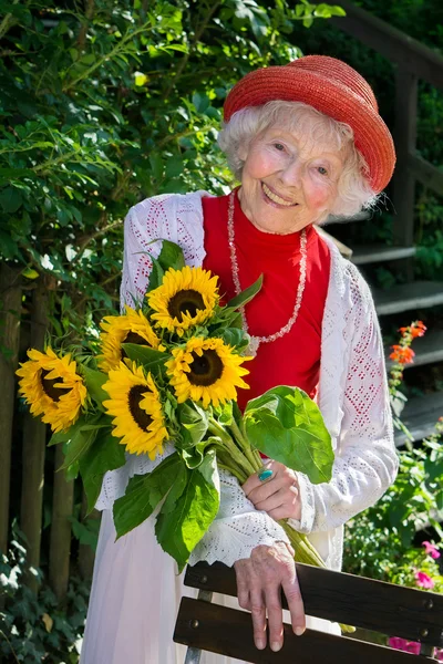 Female gardener with sunflowers — Stock Photo, Image