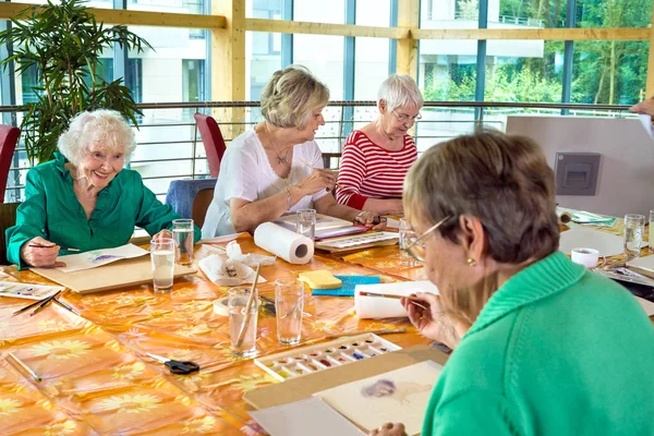 Starší ženy malba u stolu — Stock fotografie