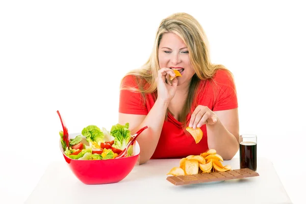 Mulher escolhendo junk food sobre frutas — Fotografia de Stock