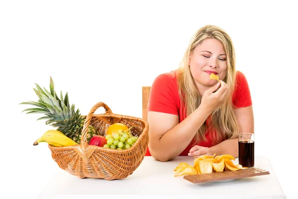 Mujer eligiendo comida chatarra sobre frutas — Foto de Stock