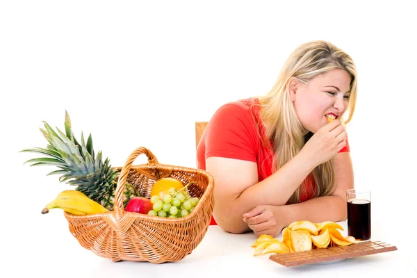 Mujer eligiendo comida chatarra sobre frutas — Foto de Stock