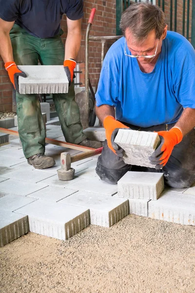 Construtores que colocam pedras de pavimentação — Fotografia de Stock