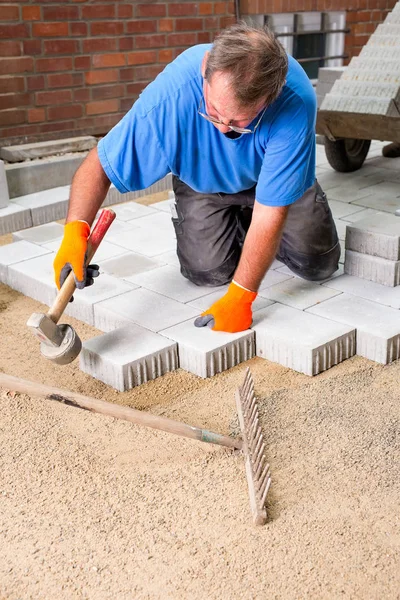 Construtor de instalação de novas pedras de pavimentação — Fotografia de Stock