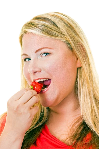 Chubby woman eating strawberry — Stock Photo, Image