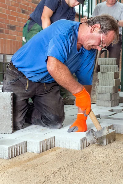 Construtores que colocam pedras de pavimentação — Fotografia de Stock