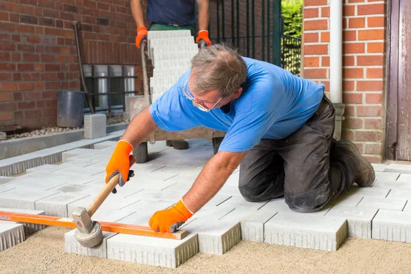 Constructor instalando nuevas piedras de pavimentación — Foto de Stock