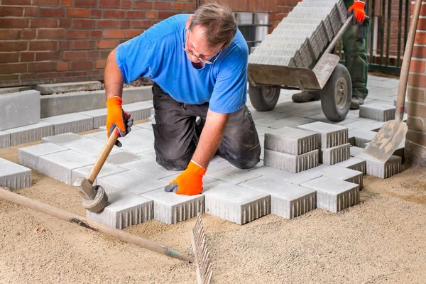 Costruttore l'installazione di nuove pietre da pavimentazione — Foto Stock