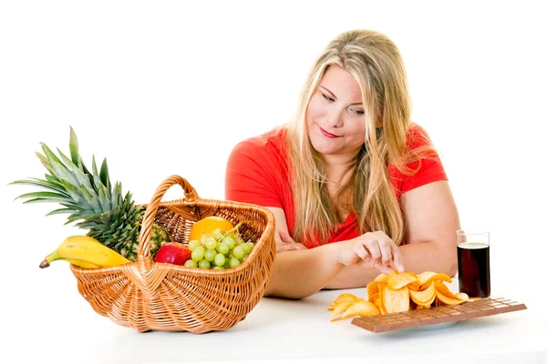 Mujer eligiendo comida chatarra sobre frutas — Foto de Stock